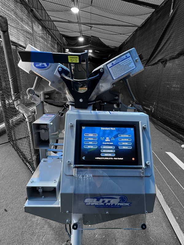 Sports Attack Elite eHack Attack pitching machine with its touchscreen in a TNXL batting cage